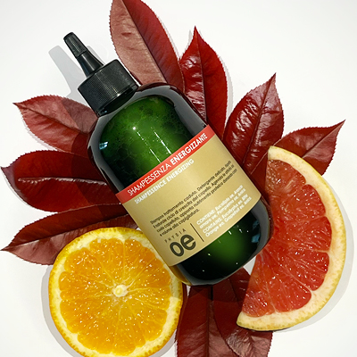 immagine del prodotto dello shampoo energizzante ambientato su sfondo neutro e attorno tutti gli ingredienti